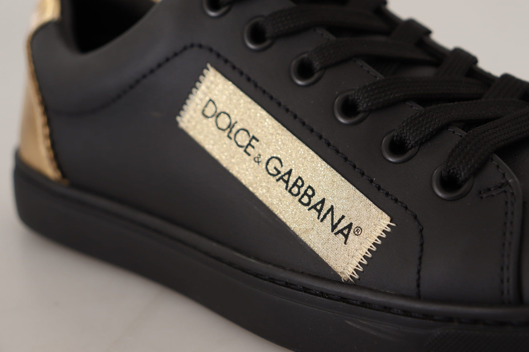 Schicke schwarze und goldene Low-Top-Sneakers aus Leder