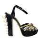 Schwarze und goldene Sandalen mit verzierten Absätzen