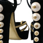 Schwarze und goldene Sandalen mit verzierten Absätzen